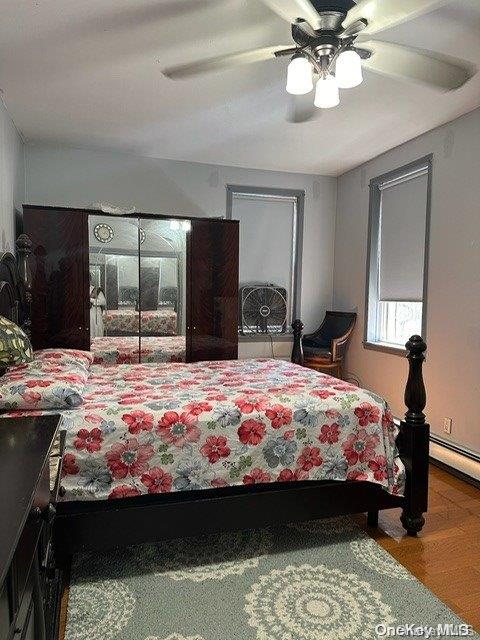 bedroom with ceiling fan and wood-type flooring