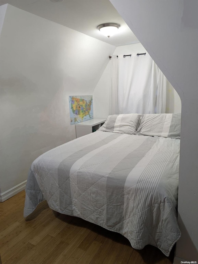 bedroom featuring hardwood / wood-style flooring and lofted ceiling