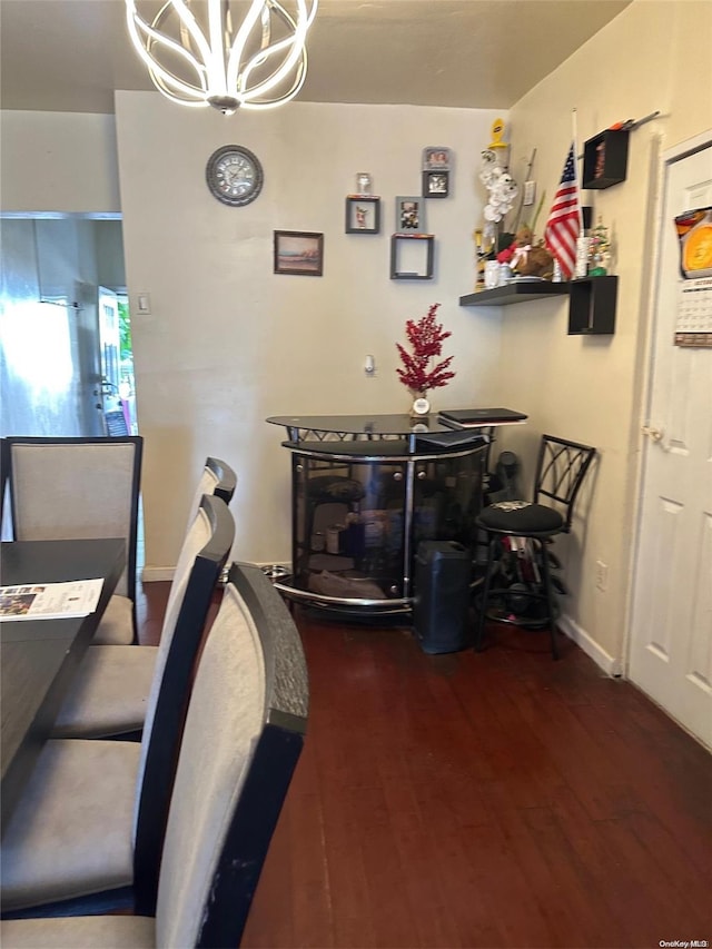 dining area with a notable chandelier and dark hardwood / wood-style floors