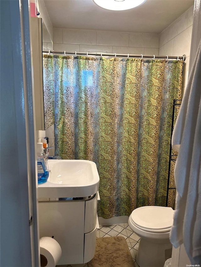 bathroom featuring tile patterned flooring, vanity, toilet, and a shower with shower curtain