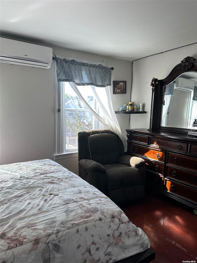 bedroom with a wall mounted AC and dark hardwood / wood-style flooring