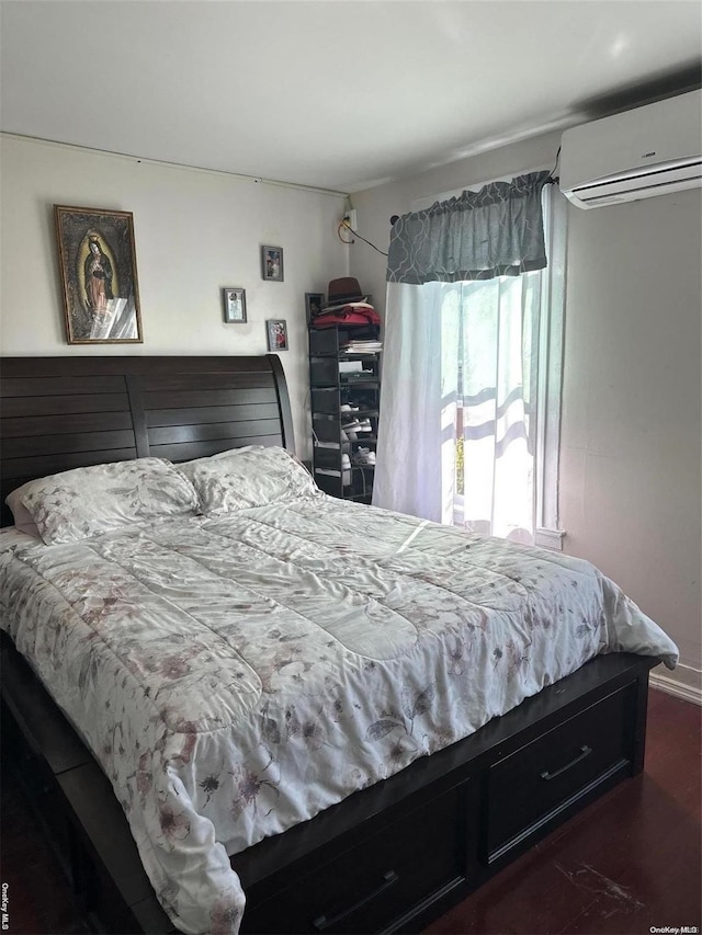 bedroom featuring dark hardwood / wood-style flooring and a wall mounted AC