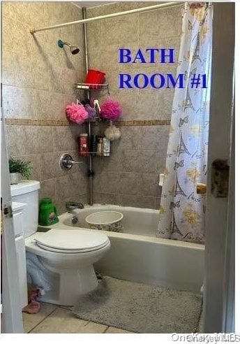 bathroom with tile patterned flooring, toilet, and shower / tub combo