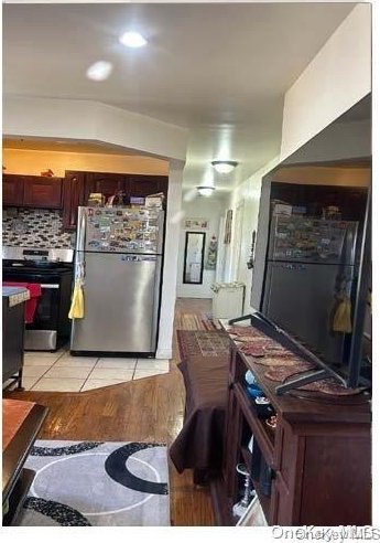 kitchen featuring light tile patterned floors, appliances with stainless steel finishes, and tasteful backsplash