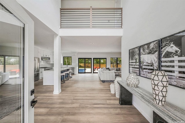 interior space with a high ceiling and light hardwood / wood-style flooring