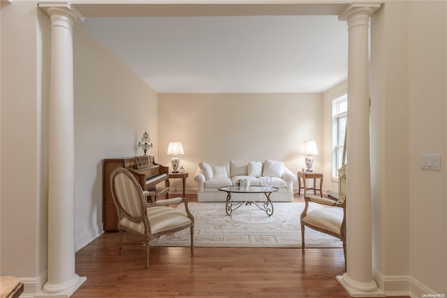 living room featuring wood-type flooring and decorative columns