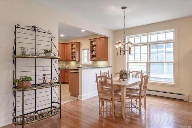 dining space featuring plenty of natural light, light hardwood / wood-style floors, and a baseboard radiator