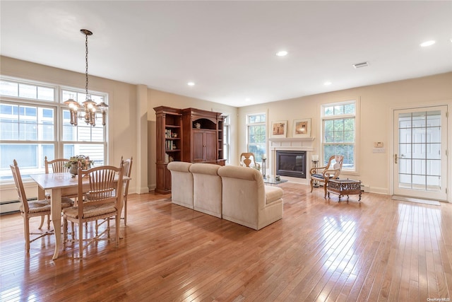 living room with a notable chandelier and light wood-type flooring