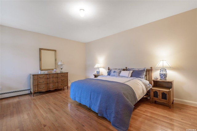 bedroom with a baseboard radiator and light wood-type flooring