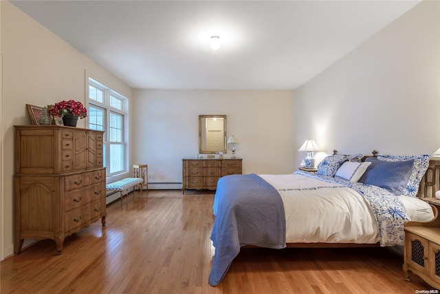 bedroom with hardwood / wood-style flooring and baseboard heating