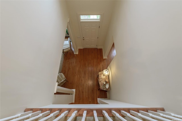 stairway featuring a towering ceiling and wood-type flooring