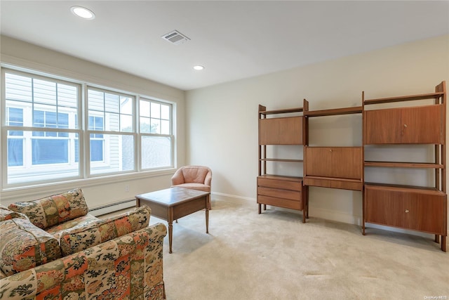 sitting room featuring light carpet and a baseboard heating unit