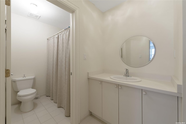 bathroom with tile patterned flooring, vanity, and toilet