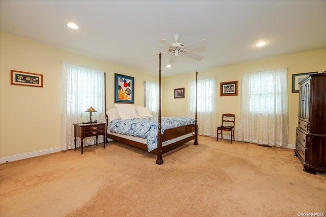 carpeted bedroom with ceiling fan and multiple windows