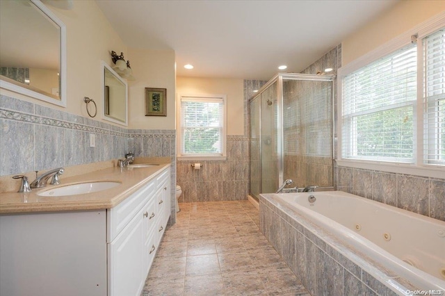 full bathroom with vanity, tile patterned floors, toilet, tile walls, and independent shower and bath