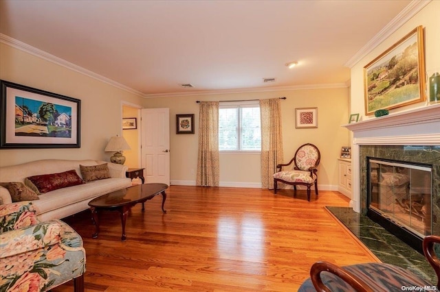 living room with light hardwood / wood-style flooring, crown molding, and a premium fireplace