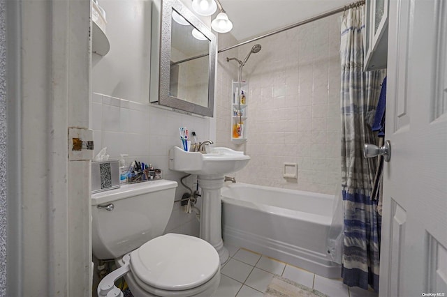 bathroom featuring tile patterned flooring, toilet, tile walls, and shower / bath combo with shower curtain