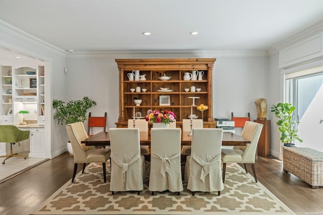 dining space with hardwood / wood-style flooring and ornamental molding