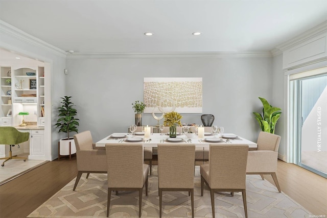 dining room with ornamental molding and light hardwood / wood-style flooring