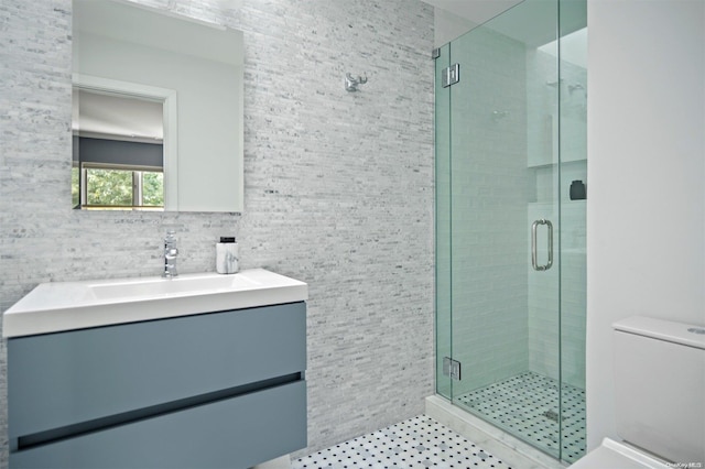 bathroom featuring an enclosed shower, vanity, toilet, and tile walls