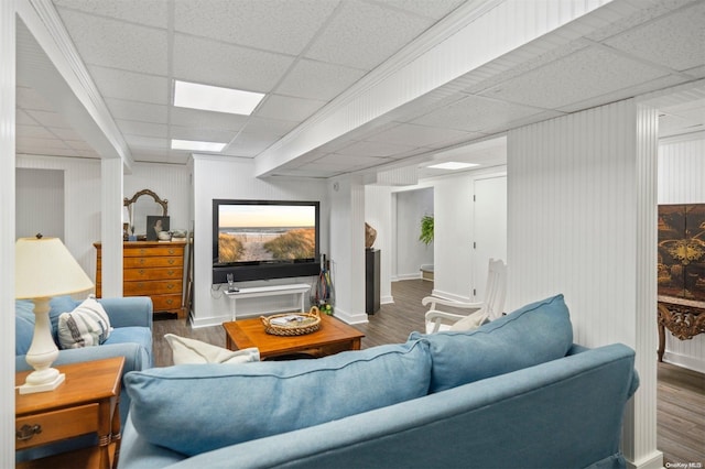 living room with dark wood-type flooring and a drop ceiling