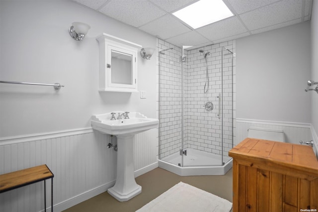 bathroom with an enclosed shower and a drop ceiling