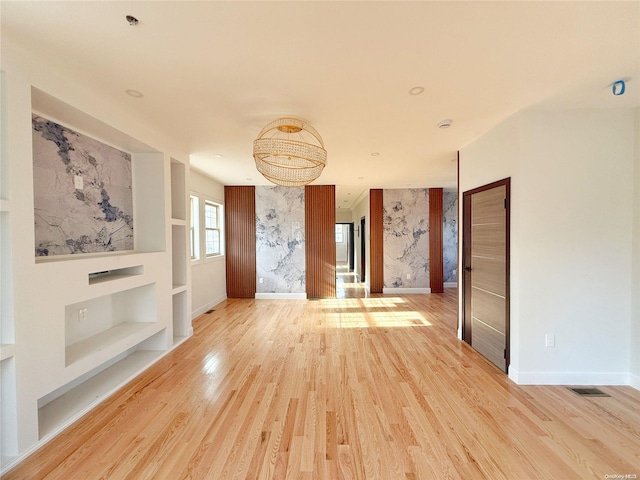 unfurnished living room featuring wood-type flooring and built in features