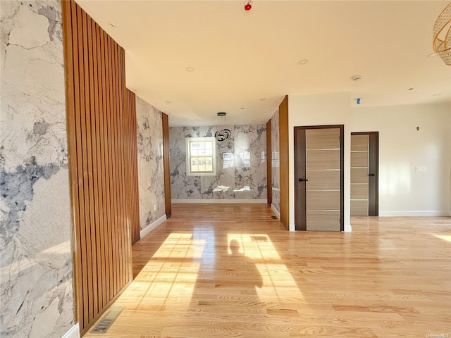 corridor with light hardwood / wood-style floors