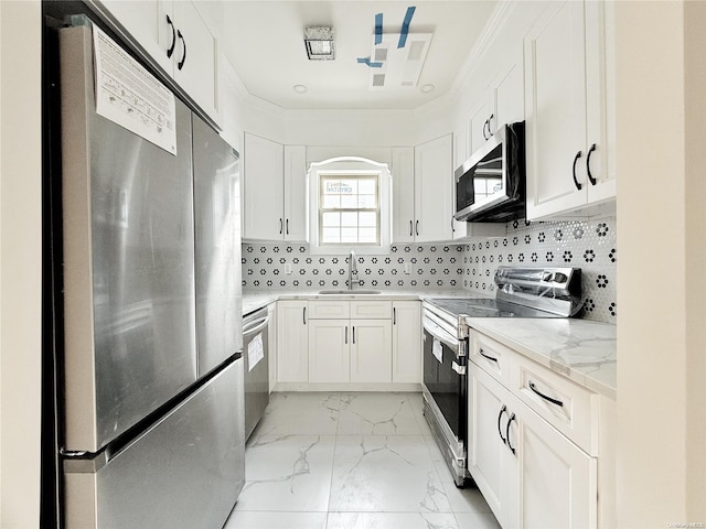 kitchen featuring light stone countertops, appliances with stainless steel finishes, tasteful backsplash, sink, and white cabinetry