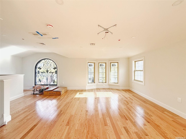 unfurnished living room with lofted ceiling and light wood-type flooring