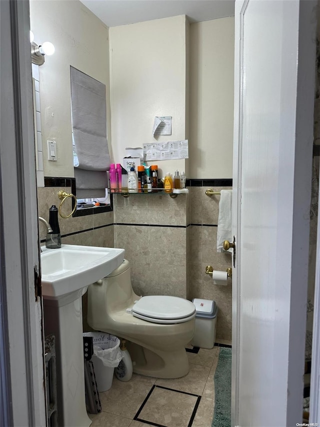 bathroom with tile patterned floors, tile walls, and toilet