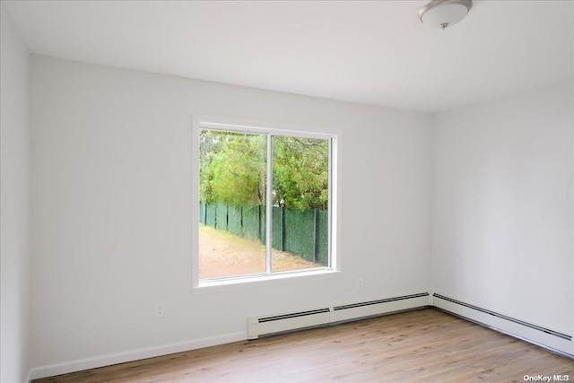 unfurnished room with a wealth of natural light, light hardwood / wood-style flooring, and a baseboard radiator