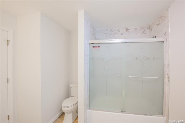 bathroom with toilet and bath / shower combo with glass door