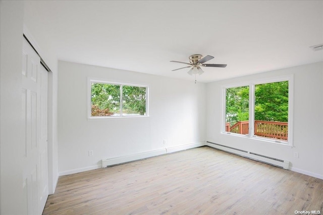 interior space featuring a closet, light hardwood / wood-style flooring, ceiling fan, and a baseboard heating unit