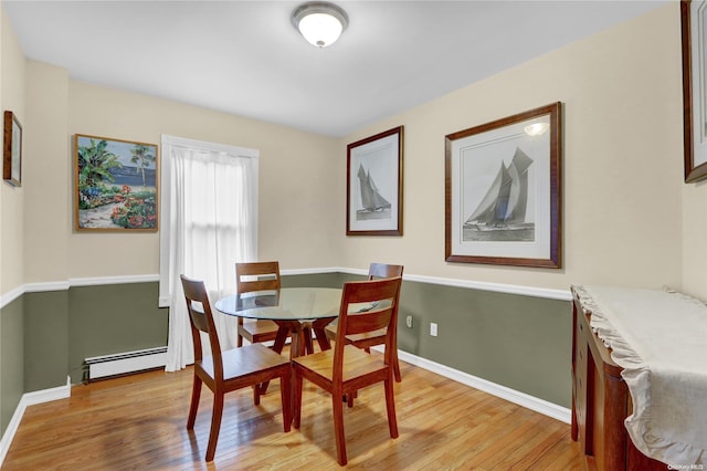 dining room with a baseboard radiator and light wood-type flooring