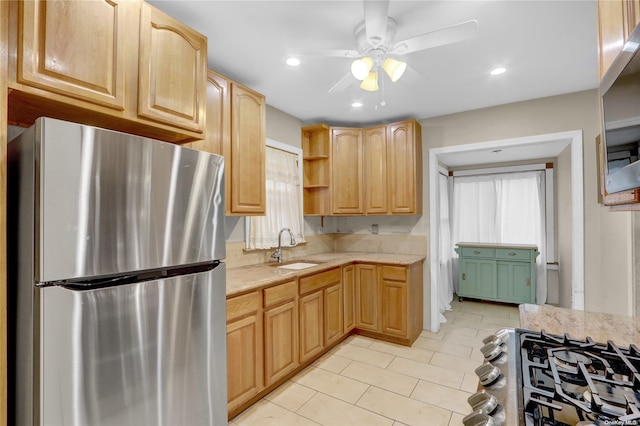 kitchen featuring ceiling fan, light brown cabinetry, sink, and appliances with stainless steel finishes