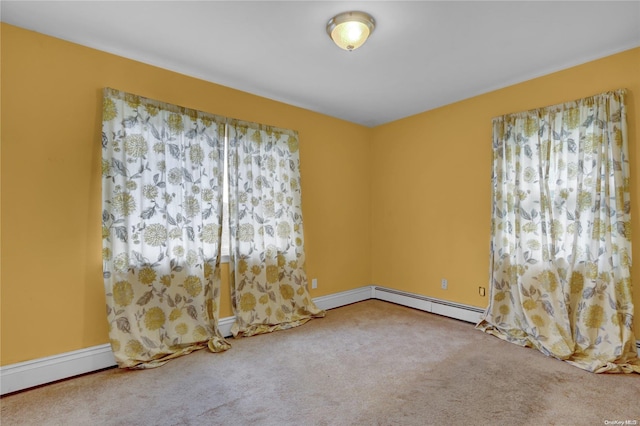 spare room with carpet and a baseboard heating unit