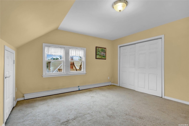 unfurnished bedroom with light carpet, a baseboard radiator, a closet, and lofted ceiling