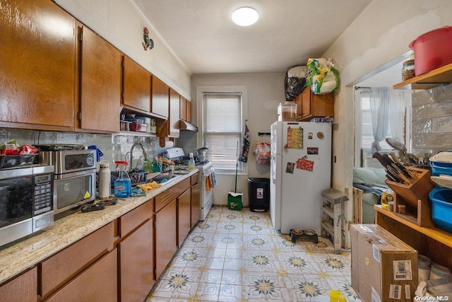 kitchen with white appliances, sink, and tasteful backsplash