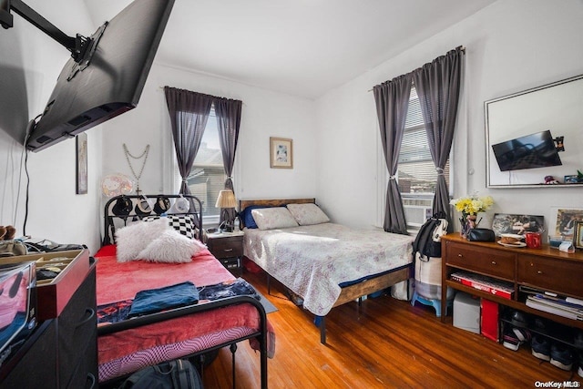 bedroom with hardwood / wood-style flooring and multiple windows