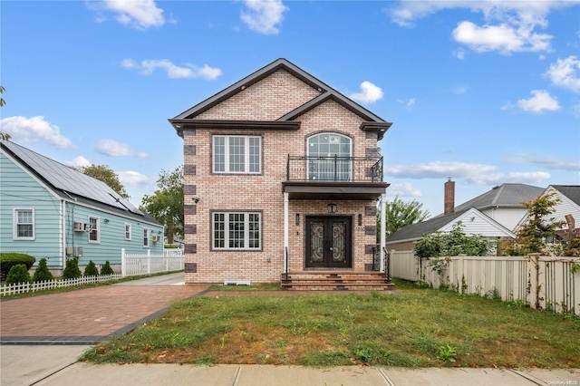 view of front of property featuring a front yard, french doors, and a balcony