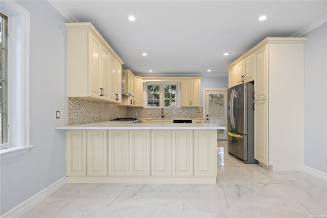 kitchen with kitchen peninsula, crown molding, and stainless steel refrigerator