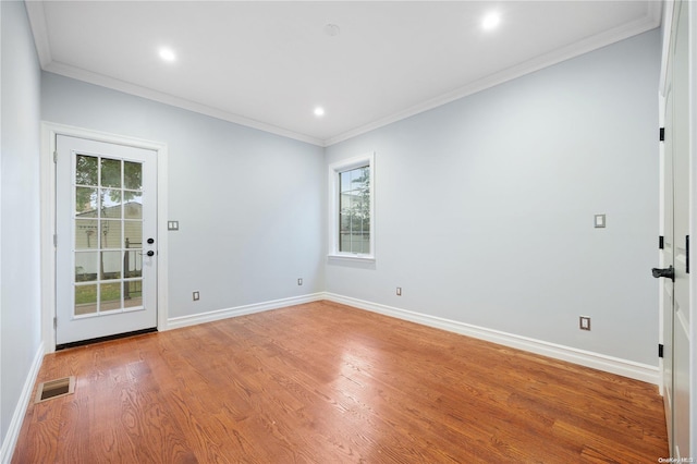 unfurnished room with light hardwood / wood-style floors, plenty of natural light, and ornamental molding