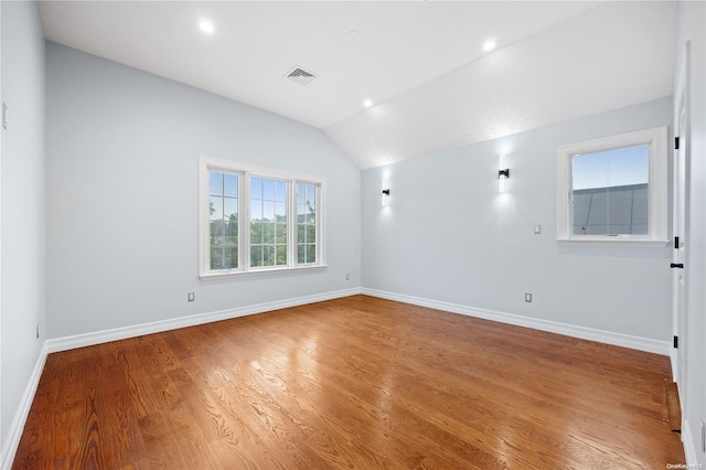 empty room with wood-type flooring and vaulted ceiling