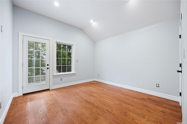 unfurnished room with light hardwood / wood-style floors and lofted ceiling