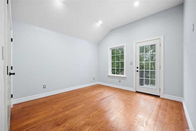 empty room featuring light hardwood / wood-style flooring and vaulted ceiling