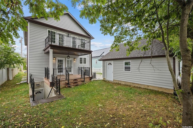 back of property featuring a yard, a balcony, and central AC unit