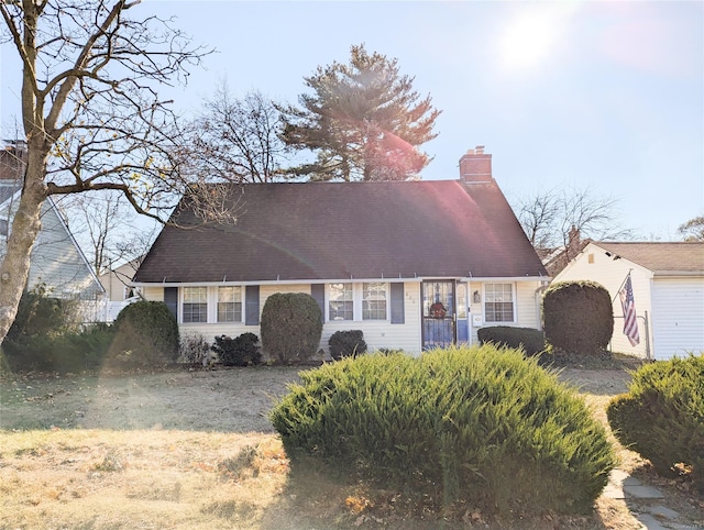 cape cod house featuring a front yard