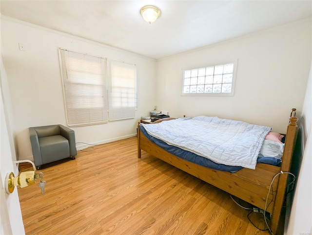 bedroom featuring light hardwood / wood-style floors and crown molding