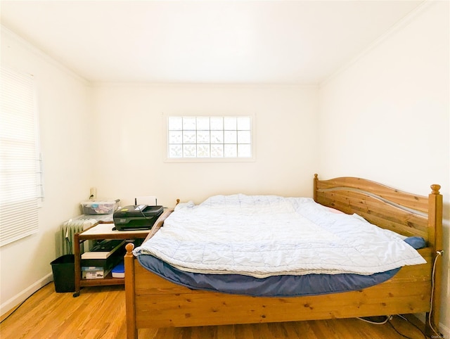 bedroom featuring wood-type flooring and ornamental molding